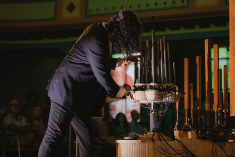 Navid Navab bending over a cluster of metal pipes, adjusting the mechanisms at their base.
